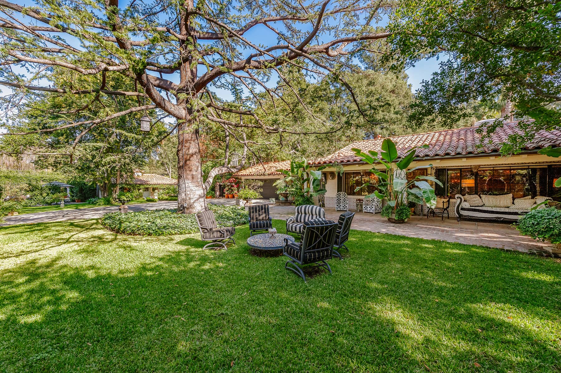 A Spanish ranch-style estate with a broad lawn and mature trees in Fryman Estates, Studio City.